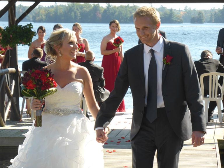 Ashley and Travis walking down the pier post wedding.