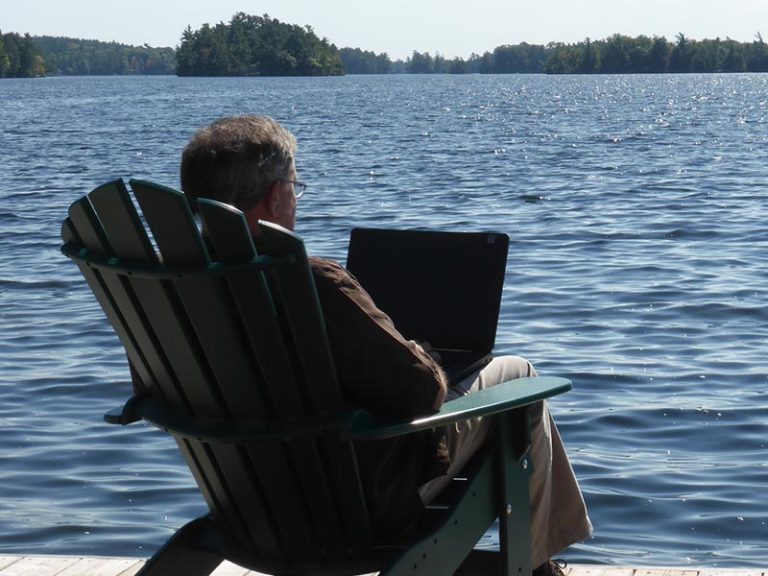 Man on the pier with a laptop.