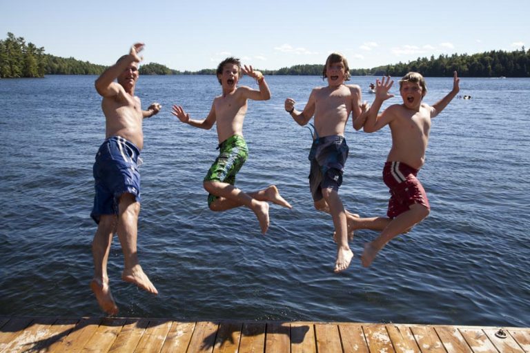 Boys jumping into the lake