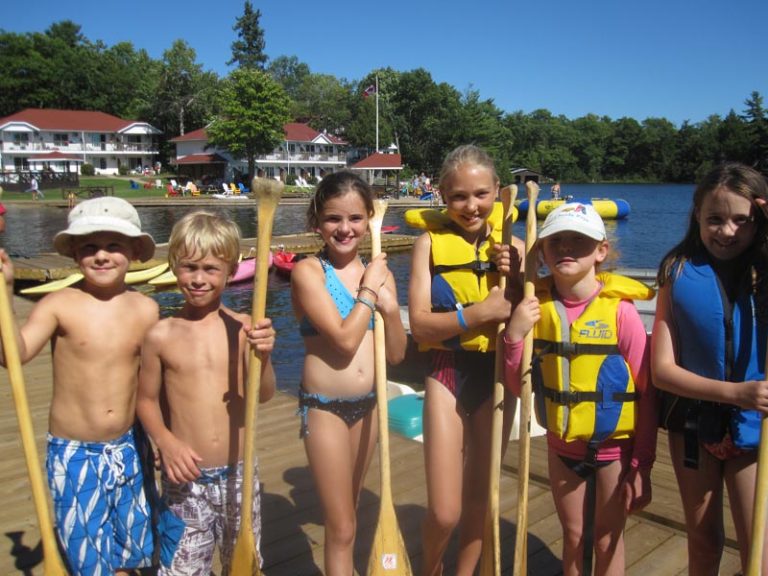 Kids on the pier holding oars