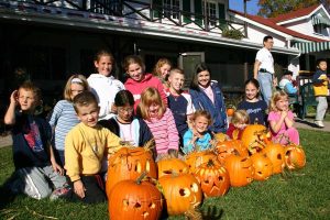 Kids posing with carved pumpkins.