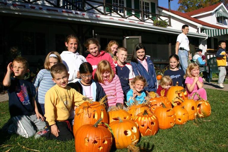 Kids posing with carved pumpkins.