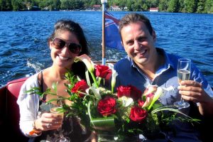 Couple on boat with wine and flowers.