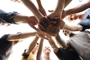 Group putting hands together in circle.