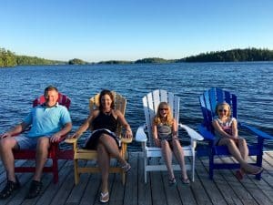 Family on Muskoka pier in Adirondack chairs.