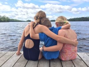 Photo of Three Kids Hugging on the Dock at Severn, One of the Most Unique Family Holidays.