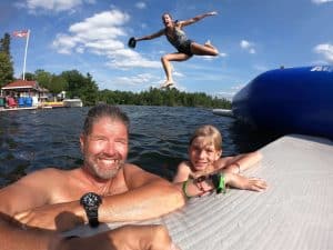 A father, mother, and son smile joyously while enjoying Gloucester Pool during their Ontario weekend family getaway in Muskoka outside of Port Severn.