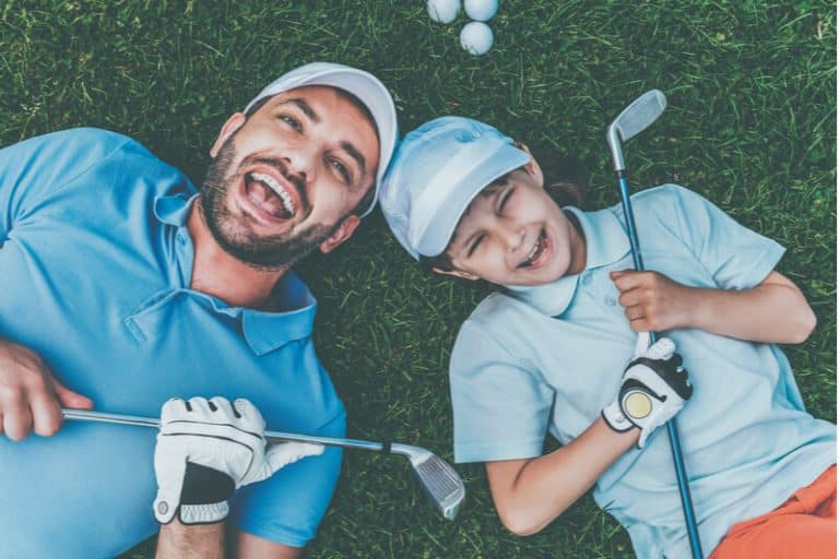 A man and his son share a laugh while holding their clubs after a fun round at one of the Muskoka golf courses near Severn Lodge.
