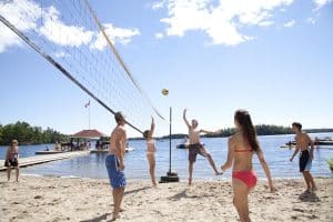 A group of guests enjoy a game of beach volleyball at Severn Lodge, an all-inclusive vacation resort along Gloucester Pool in the Muskoka Lake District.