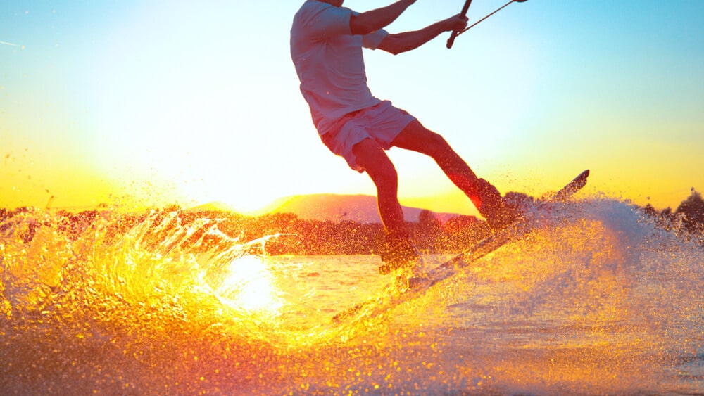 A wakeboarder catches air on a turbulent wave.