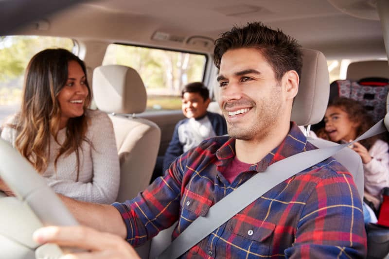 A young family smiles as they make their way from Toronto to Muskoka.