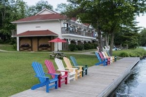 Muskoka chairs lined up along the dock.