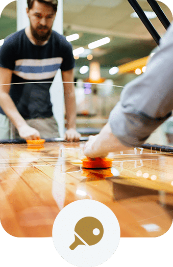 Two friends playing air hockey