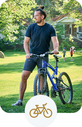 Man standing beside a mountain bike on a sunny day