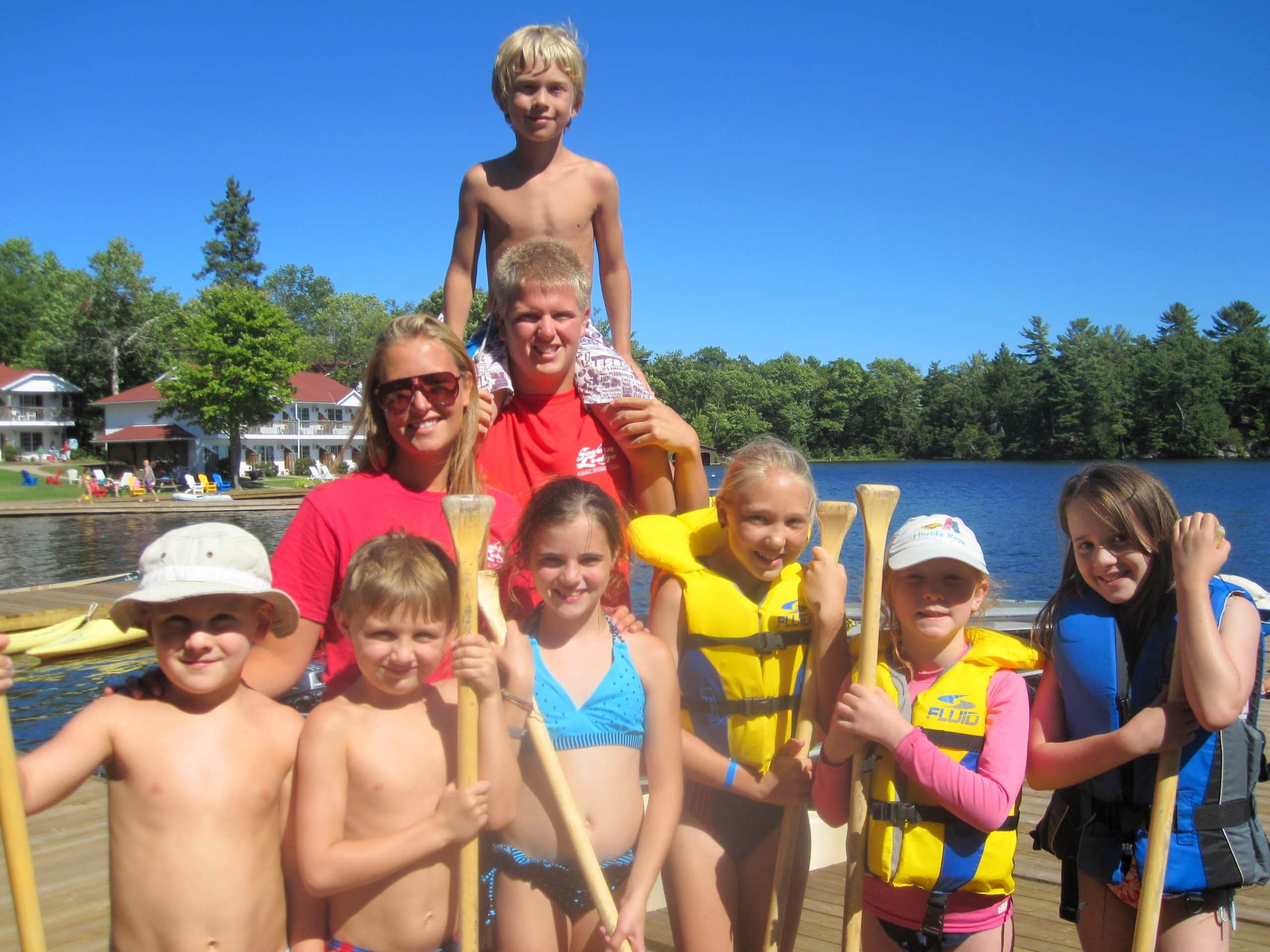 A group of kids on a dock about to go paddling