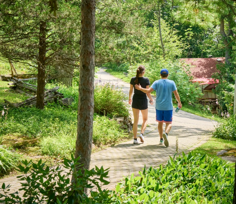 Muskoka Getaways for Couples: A romantic couple embrace as they walk along the hiking trails at Severn Lodge.