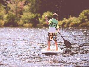 Muskoka Summer: A young adventurer enjoys paddleboarding at a Muskoka family resort on Gloucester Pool near Port Severn, ON.